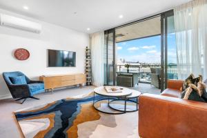 Wynyard Quarter Apartments by Urban Rest في أوكلاند: غرفة معيشة بها أريكة وطاولة