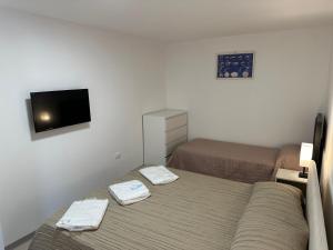 a small bedroom with two beds and a flat screen tv at Villa Portoferraio in Portoferraio