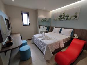 une chambre d'hôtel avec un lit et un fauteuil rouge dans l'établissement khách sạn tina 5, à Cần Thơ