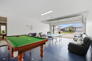 a living room with a pool table and couches at Cowes Family Beach House in Cowes