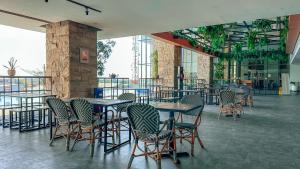 ein Restaurant mit Tischen und Stühlen in einem Gebäude in der Unterkunft Swiss-Belinn Karawang in Karawang