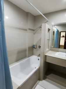 La salle de bains blanche est pourvue d'une baignoire et d'un lavabo. dans l'établissement Morakot Twin Chumphon, à Chumpon