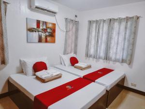 um quarto com duas camas com detalhes em vermelho em MKB Pension em Coron