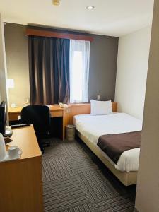 a hotel room with a bed and a desk at Hotel Hanaya in Tanabe