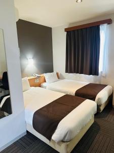 a hotel room with two beds and a window at Hotel Hanaya in Tanabe