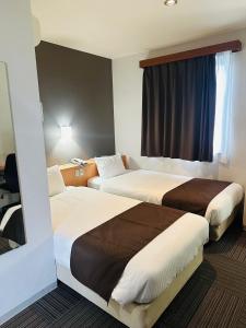 ein Hotelzimmer mit zwei Betten und einem Fenster in der Unterkunft Hotel Hanaya in Tanabe