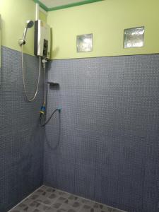 a shower in a bathroom with a tiled wall at Grandma's House in Khao Sok National Park