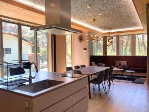 a kitchen with a sink and a table with chairs at Tabinoteitaku Zao Miyagi in Zao