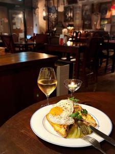a plate of food with an egg and a glass of wine at Hotel Hanaya in Tanabe