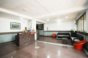 a man standing at a counter in a lobby at Springfield Family Apartment in Mahabaleshwar