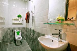 ein kleines Bad mit einem Waschbecken und einem WC in der Unterkunft Happy Town Hoi An in Hoi An