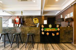 a bar with stools in a room with a counter at Golden Roof Hotel, Seri Iskandar in Seri Iskandar