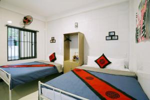 a bedroom with two beds and a window at Happy Town Hoi An in Hoi An