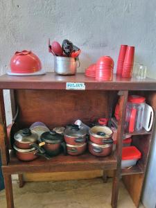 a wooden shelf with pots and pans and plates at Jurema Camping in Itacaré
