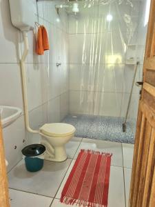 a bathroom with a shower with a toilet and a rug at Jurema Camping in Itacaré