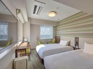 una camera d'albergo con due letti e una scrivania di Hearton Hotel Shinsaibashi Nagahoridouri ad Osaka