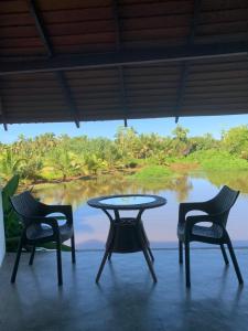 een tafel en stoelen met uitzicht op een meer bij Jungle Heart Cabanas in Danwattegoda