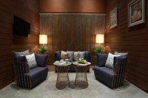 香港的住宿－香港觀塘帝盛酒店，客厅配有两把椅子和一张桌子