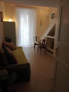 a living room with a couch and a table and chairs at Casa di Ida in Locri