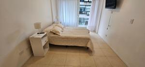 a small bedroom with a bed and a window at FLORIDA Apartment in Buenos Aires