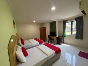 a hotel room with two beds and a desk at HOTEL SAHARA INN BATU CAVES in Batu Caves