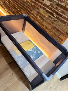Bear Homes - Olimpia Suite في فالنسيا: إطار سرير فارغ على طاولة بجوار جدار من الطوب