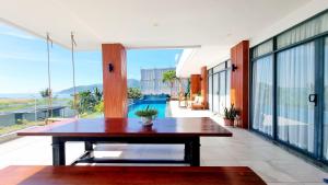 a dining room with a table and large windows at Ocean Beach Villa Nha Trang in Nha Trang