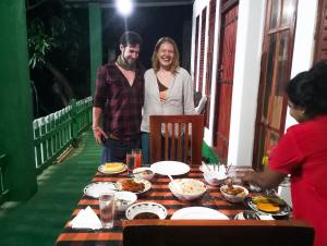 Ein Mann und eine Frau stehen um einen Tisch mit Essen in der Unterkunft Jm Resort in Dambulla