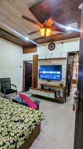 Un dormitorio con una cama y un ventilador de techo. en Agastya HomeStay by PR, en Varanasi