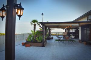 patio ze stołem i krzesłami oraz werandą w obiekcie B&B Terrazza dell'Etna w mieście Mascalucia
