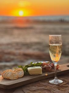 a glass of wine next to a plate of food at Botanica Editions at Sanctuary Resort in Broome