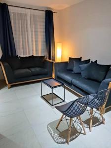 sala de estar con sofá azul y sillas en Casa Santa fe, en Aguascalientes