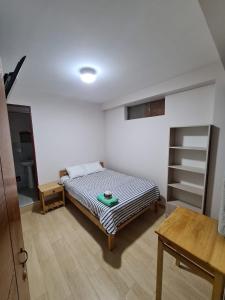 ein Schlafzimmer mit einem Bett und einem Tisch darin in der Unterkunft LIRI House in Oxapampa
