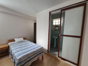 um quarto com uma cama, uma janela e uma casa de banho em LIRI House em Oxapampa