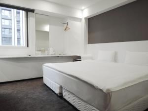 a white bedroom with a large bed and a window at CHECK inn Express Taipei Yongkang in Taipei