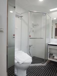 a white bathroom with a shower and a toilet at CHECK inn Express Taipei Yongkang in Taipei
