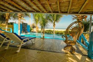 patio z krzesłami, basenem i palmami w obiekcie Casa Estrella de Mar w mieście Zorritos