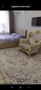 ein Schlafzimmer mit einem Bett, einem Sofa und einem Teppich in der Unterkunft 1комнатная квартира in Bischkek