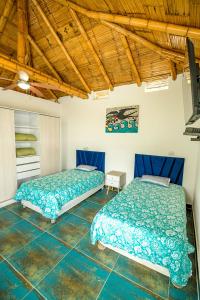 2 camas en una habitación con sábanas azules en Casa Estrella de Mar, en Zorritos