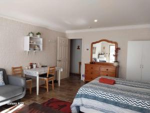 1 dormitorio con cama, mesa y espejo en Sweet Home by the Golf Course en Canberra