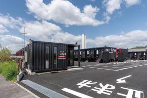 a row of black containers in a parking lot at HOTEL R9 The Yard Kanra in Kanra