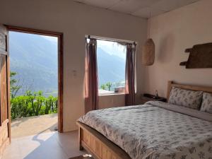 a bedroom with a bed and a large window at Lagom home - Cactus in Sapa
