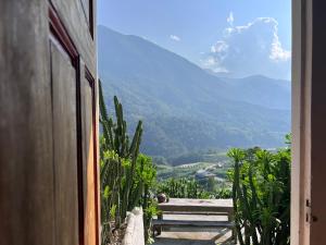 a view from a door of a bench and a mountain at Lagom home - Cactus in Sapa