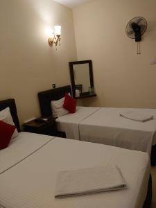 Cette chambre comprend 2 lits et un miroir. dans l'établissement Forever City Hotel, à Kiribathgoda