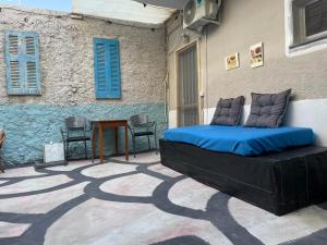 卡達麥納的住宿－Efi studios 2，一张位于带蓝色百叶窗的庭院的床铺