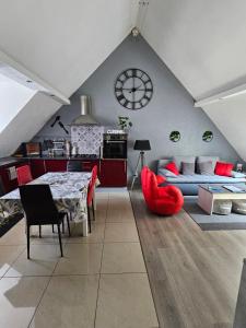 a kitchen and living room with a table and red chairs at Gîte Vallée de Munster chez Flavie & Ludo in Muhlbach-sur-Munster