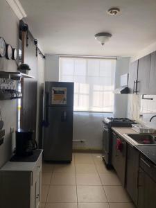 a kitchen with a stainless steel refrigerator and a window at Mistic hills in Panama City