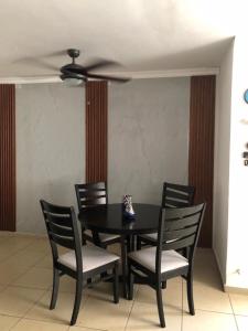 a black dining room table with chairs and a ceiling fan at Mistic hills in Panama City
