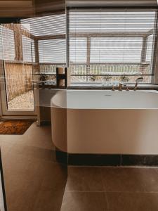 a bath tub in a bathroom with a large window at Maas Suites (Maastricht - Lanaken) in Lanaken