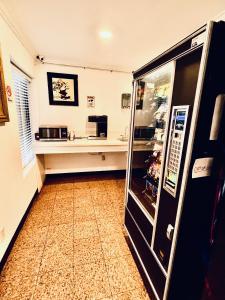 a kitchen with a refrigerator and a counter at 777 Motor Inn in Huntington Beach